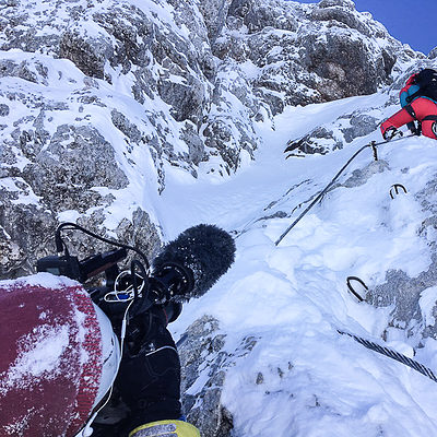 Kamerateam filmt Bergsteiger beim Klettern im verschneiten Gebirge für professionelle Videoproduktion
